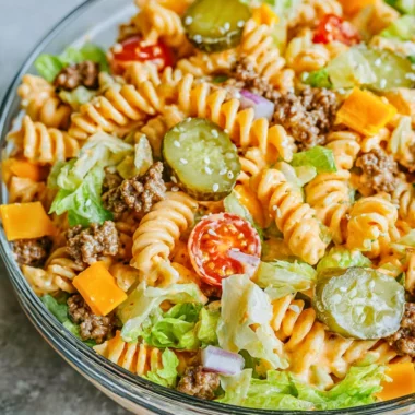 Big Mac Pasta Salad served in a bowl, garnished with lettuce and tomatoes.