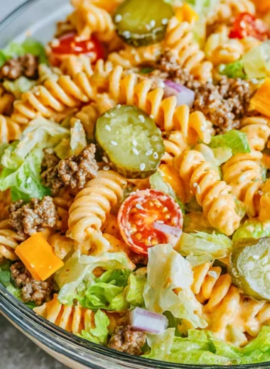 Big Mac Pasta Salad served in a bowl, garnished with lettuce and tomatoes.