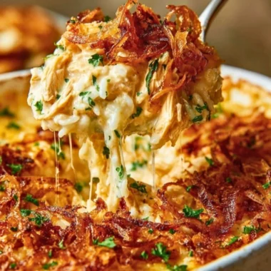 Creamy French onion chicken served over rice, garnished with herbs.