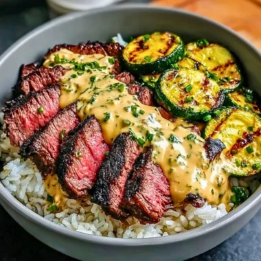 Delicious Grilled Steak Bowl with sauce and grilled zucchini served in a bowl.