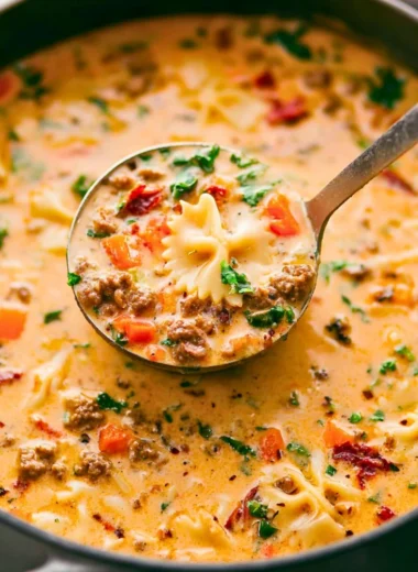 Bowl of Italian Sausage Pasta Soup with vegetables and herbs