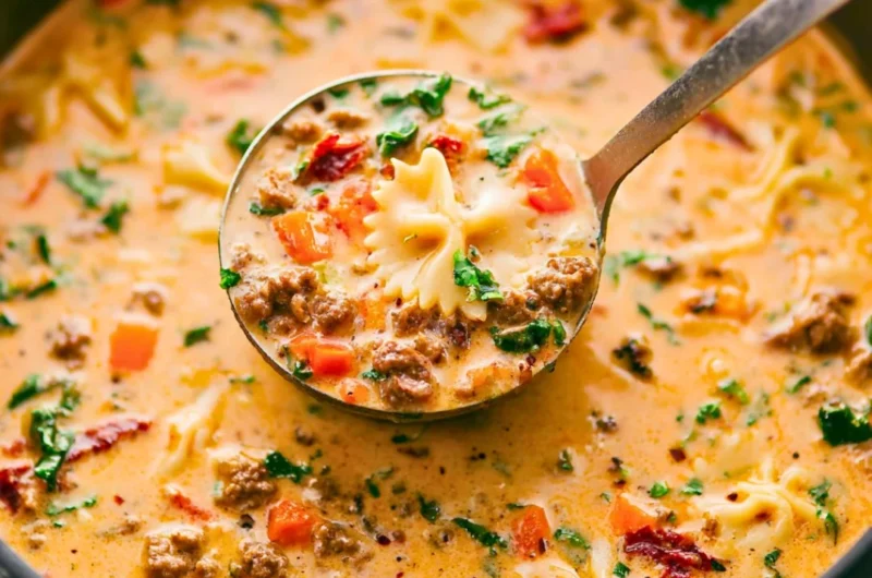 Bowl of Italian Sausage Pasta Soup with vegetables and herbs