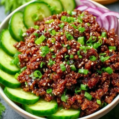 Delicious Spicy Keto Korean Beef served with cucumber salad on a plate.