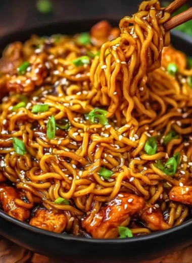 Sticky garlic chicken noodles dish with vegetables and herbs