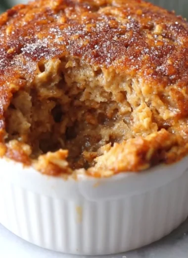Freshly baked oatmeal muffins on a wooden table with oats and berries
