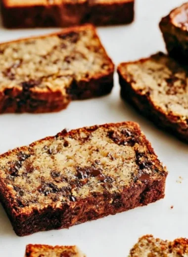 Slice of chocolate chip banana bread on a wooden board