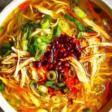 A bowl of Classic Ginger Garlic Chicken Noodle Soup with garnishes