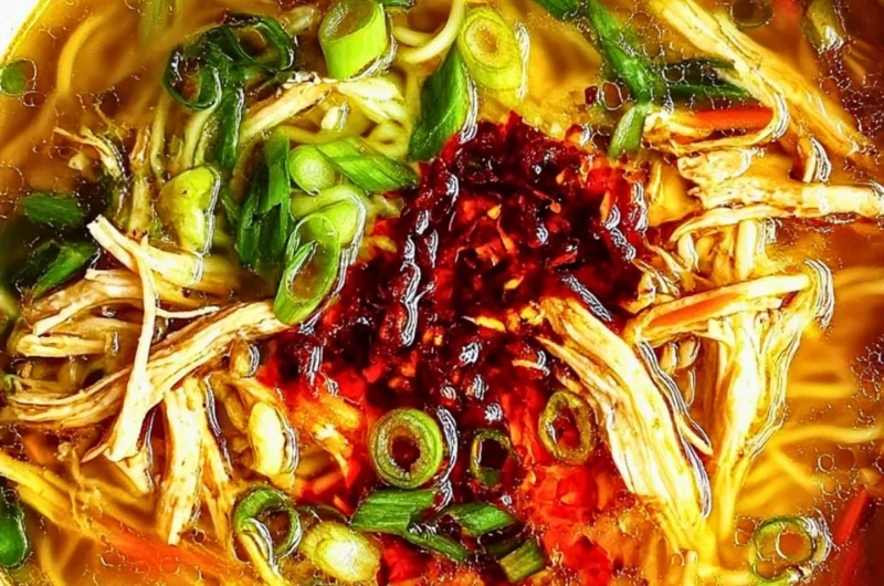 A bowl of Classic Ginger Garlic Chicken Noodle Soup with garnishes