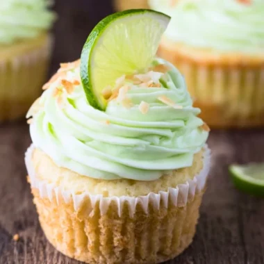 Delicious coconut cupcakes with lime buttercream frosting on a decorative plate.