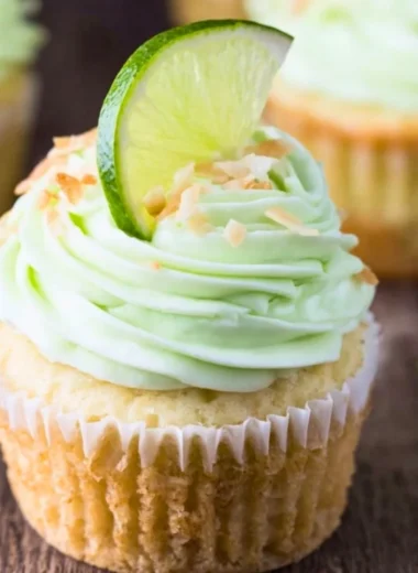 Delicious coconut cupcakes with lime buttercream frosting on a decorative plate.
