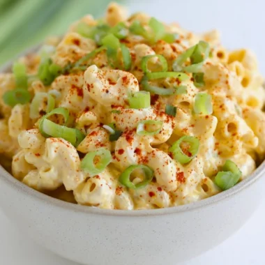 Delicious deviled egg pasta salad in a bowl, garnished with herbs.