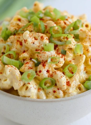 Delicious deviled egg pasta salad in a bowl, garnished with herbs.