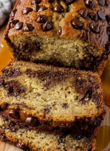 Slice of easy chocolate chip banana bread on a wooden cutting board