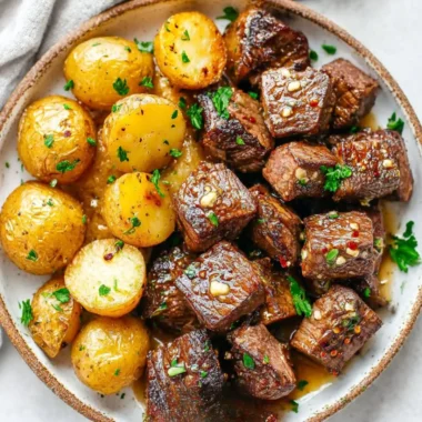 Garlic steak bites served with crispy potatoes on a plate