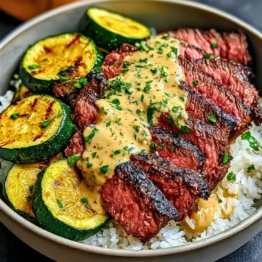 Grilled steak bowl garnished with sauce and grilled zucchini on a plate.