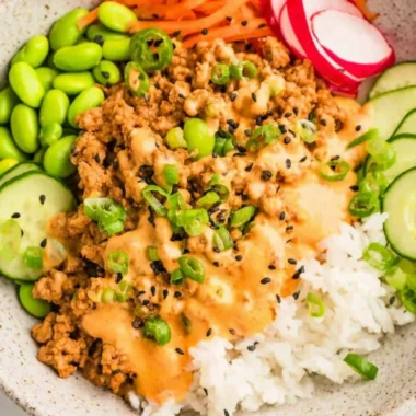 Ground turkey rice bowl topped with Bang Bang sauce and vegetables