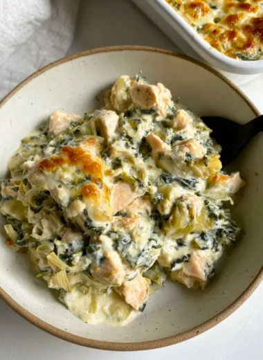 High-protein spinach artichoke chicken casserole served in a baking dish