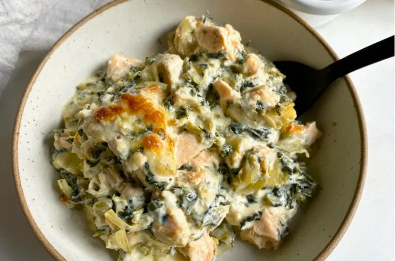 High-protein spinach artichoke chicken casserole served in a baking dish