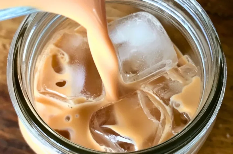 Iced English Tea Latte served in a glass with ice and tea leaves