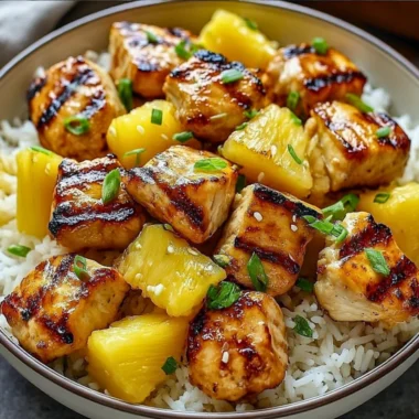 Pineapple Chicken served with rice on a plate garnished with green onions