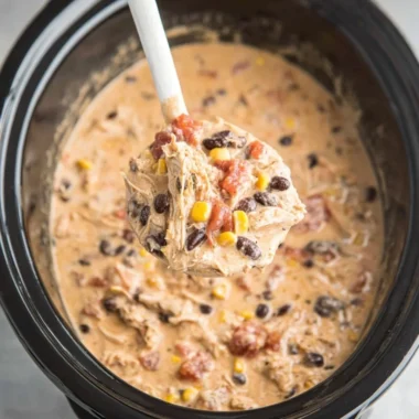 Bowl of delicious crockpot white chicken chili topped with cilantro and cheese