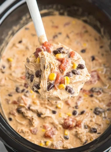 Bowl of delicious crockpot white chicken chili topped with cilantro and cheese