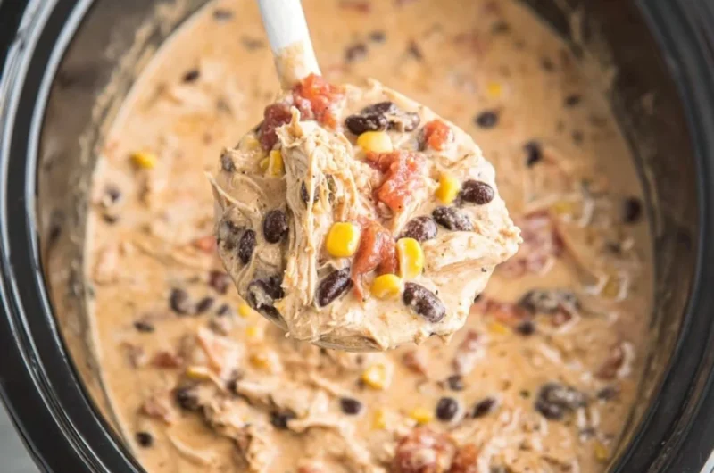 Bowl of delicious crockpot white chicken chili topped with cilantro and cheese