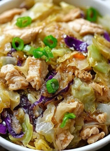 A colorful egg roll bowl featuring chicken, cabbage, and fresh vegetables.