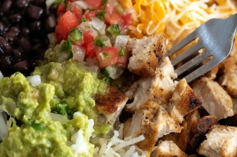 Grilled chicken burrito bowl featuring rice, beans, and fresh toppings.