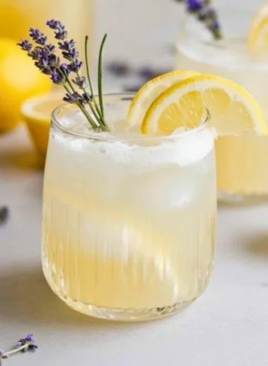 Refreshing Coconut Lavender Lemonade Mocktail with lavender flowers and coconut slices
