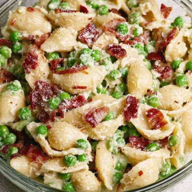 Creamy Pea and Bacon Pasta Salad served in a bowl with fresh herbs
