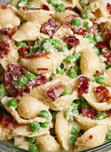 Creamy Pea and Bacon Pasta Salad served in a bowl with fresh herbs