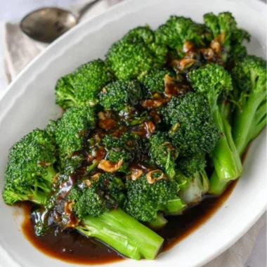 Plate of easy broccoli with garlic sauce garnished with herbs
