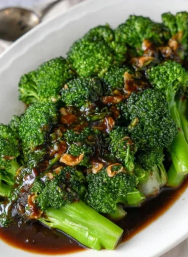 Plate of easy broccoli with garlic sauce garnished with herbs