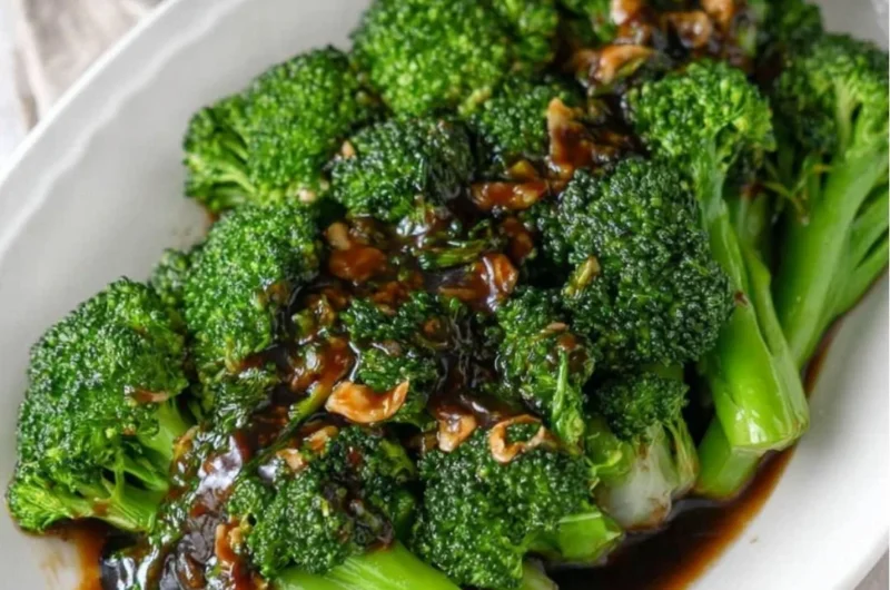 Plate of easy broccoli with garlic sauce garnished with herbs
