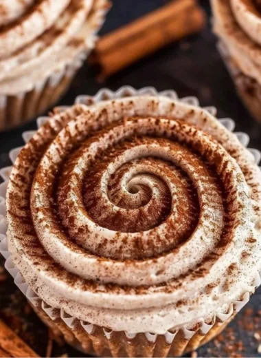 Mini no bake cinnamon roll cheesecakes topped with cinnamon swirl.