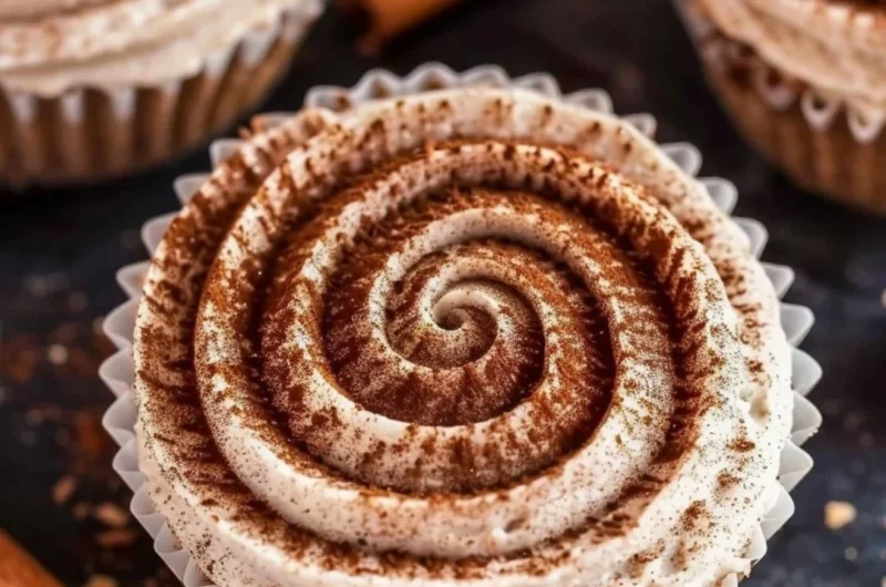 Mini no bake cinnamon roll cheesecakes topped with cinnamon swirl.