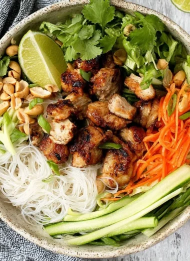 Vietnamese noodle bowl with lemongrass chicken garnished with fresh herbs